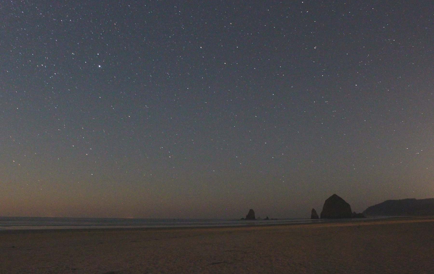 Rare form of nightglow in Cannon Beach, Oregon coast: note the thin, faint yellow line